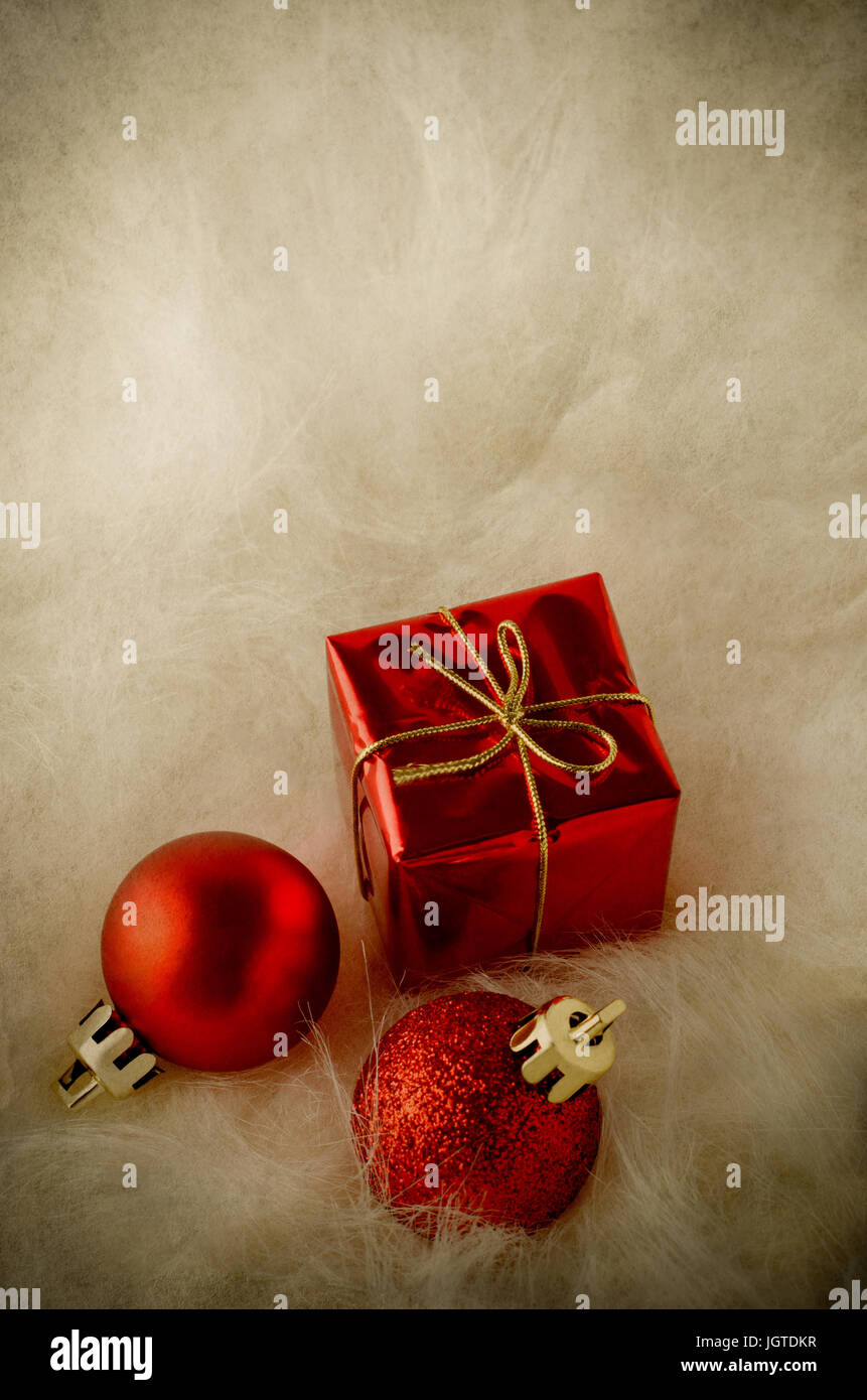 Colpo verticale di rosso le decorazioni di Natale nella metà inferiore del telaio, giacente in con i capelli lunghi finta pelliccia. Invecchiato per effetto vintage. Foto Stock