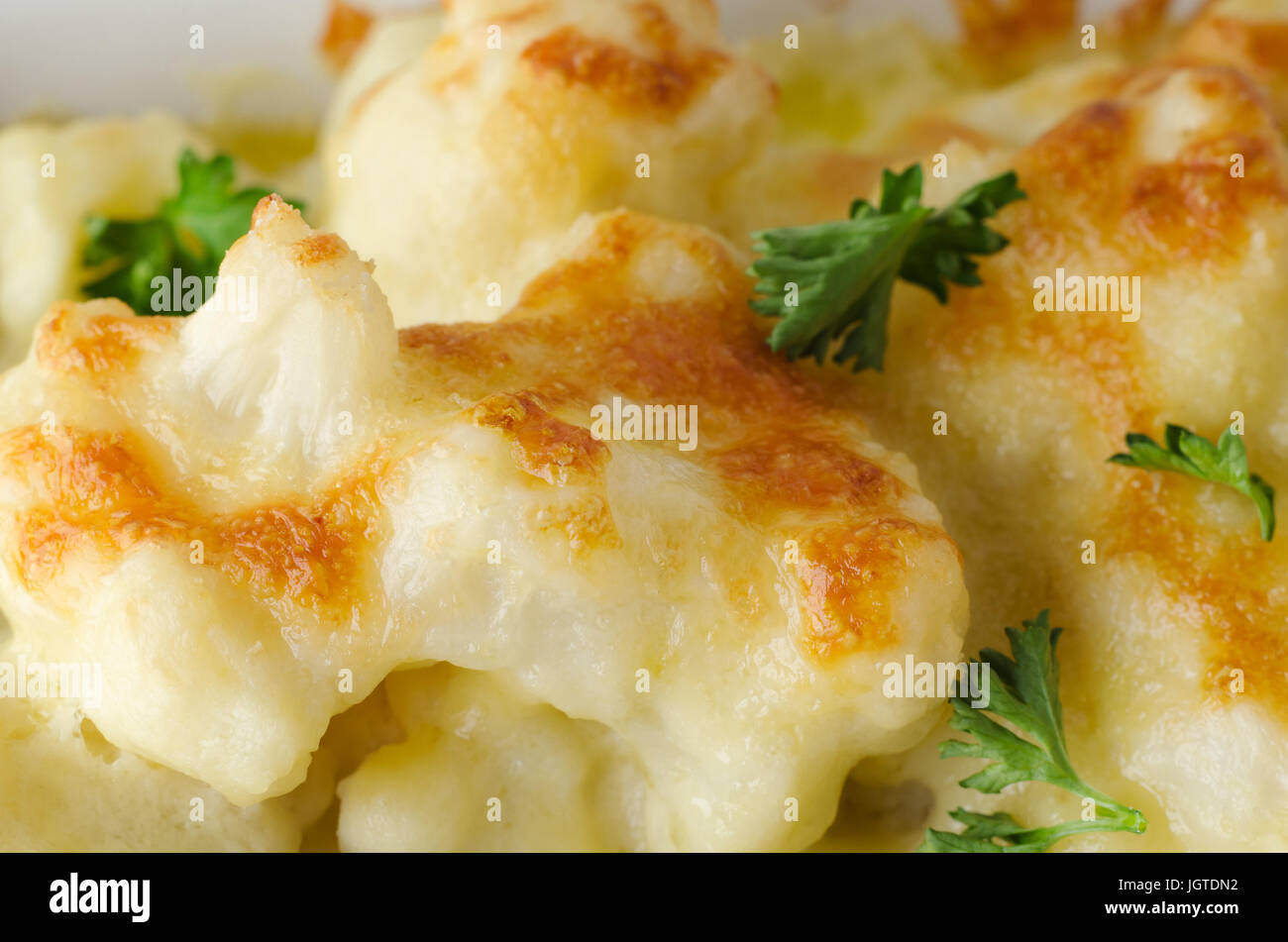 Close up (macro) di Cavolfiore al forno con formaggio sparsi prezzemolo guarnire. Foto Stock