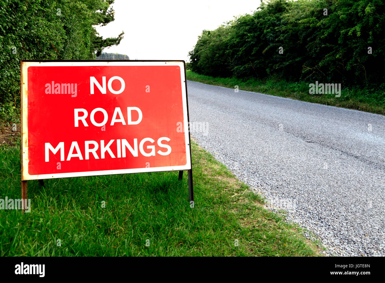 Assenza di indicazioni stradali, segno, nuovo manto stradale, il traffico inglese cartelli di avvertimento, England, Regno Unito Foto Stock