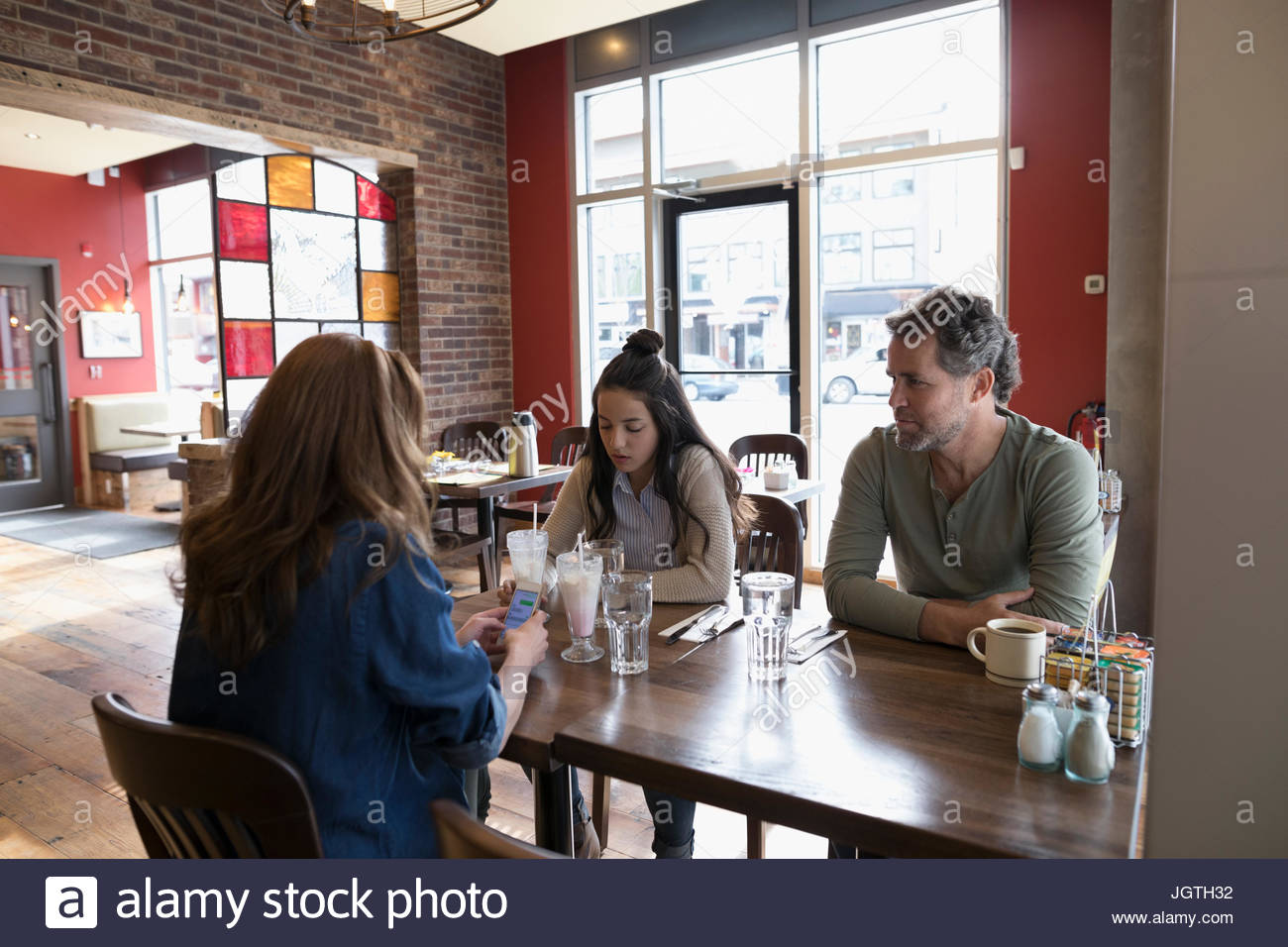 I genitori con figlia adolescente cenare al tavolo da pranzo Foto Stock