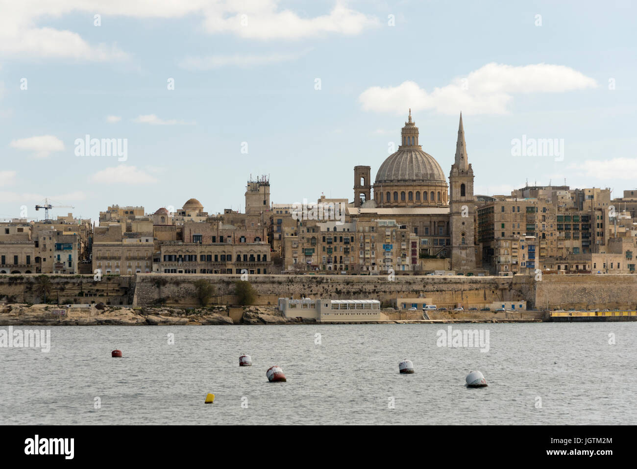 Una vista di Valletta, la capitale di Malta attraverso il porto da Sliema che mostra la chiesa carmelitana la cupola e la torre Foto Stock