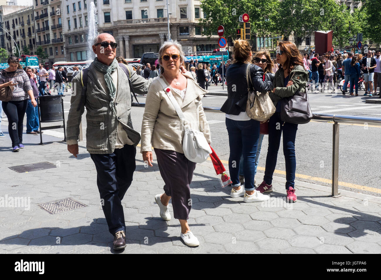 Un giovane con una rosa rossa a piedi lungo la Gran Via de les Corts Catalanes su Sant Jordi giorno, Barcelona, Spagna. Foto Stock