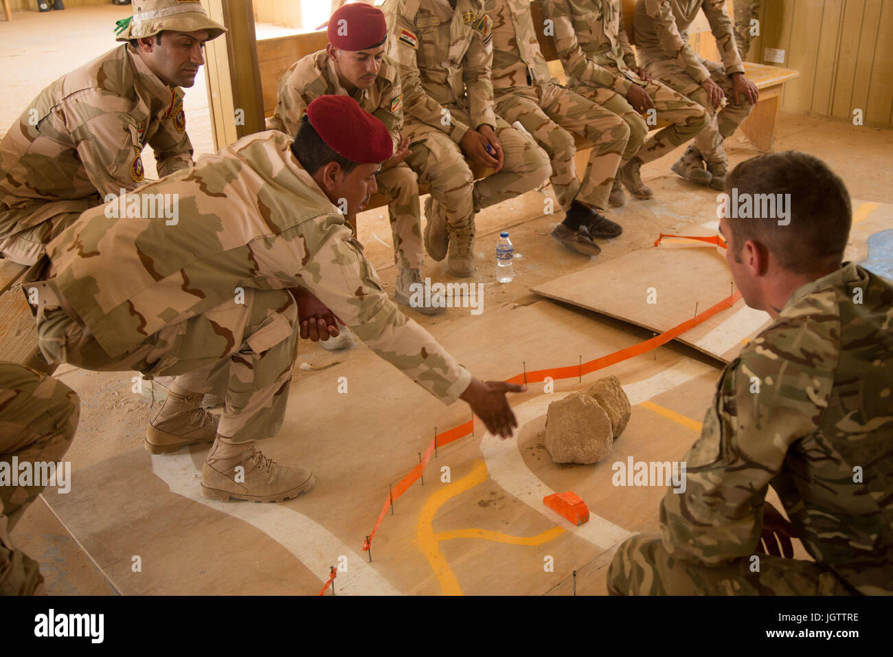 Un soldato iracheno mostra British trainer lancia Cpl. Andrew dove avrebbe potuto sospettare una improvvisata dispositivo esplosivo per essere posizionato durante un contatore I.E.D. classe a Camp Al Asad, Iraq, 2 luglio 2017. Questo corso di formazione è fondamentale per consentire le forze di sicurezza locali per liberare la loro patria da ISIS. CJTF-funzione OIR è la coalizione globale per sconfiggere ISIS in Iraq e la Siria. (U.S. Esercito foto di Spc. Cole Erickson) Foto Stock