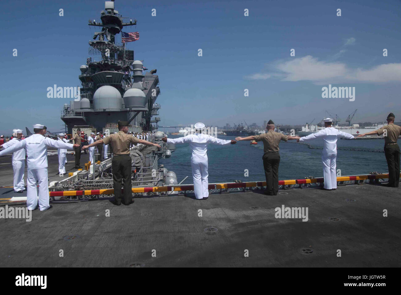 I Marines e i marinai del 15th MEU e America Amphibious Ready Group eseguono la tradizione navale di equipaggiare i binari a bordo della USS America (LHA 6) sul ponte di volo. Tale prassi onora le dogane marittime e dimostra rispetto durante lo spiegamento. Foto Stock
