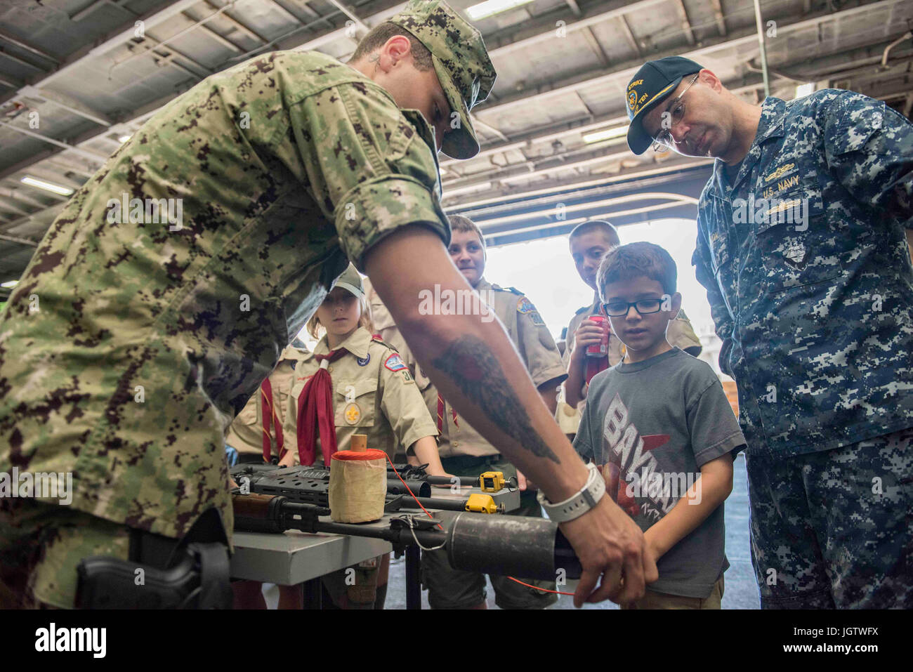 Il personale di sicurezza a bordo della portaerei USS Dwight D. Eisenhower (CVN 69) dimostra e spiega i fucili ai visitatori durante una crociera di un giorno con amici e familiari mentre la nave opera in fase di mantenimento del piano di risposta della flotta ottimizzato. Foto Stock