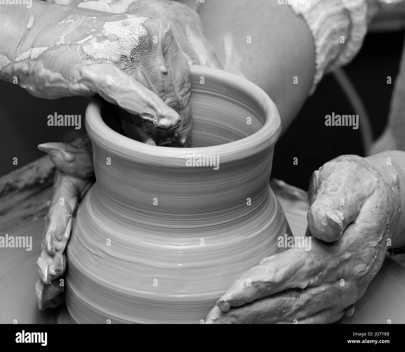 Visualizzazione bianco e nero di due donne nel processo di realizzazione di vaso di creta sulla ruota di ceramiche. Vasai al lavoro. Foto Stock