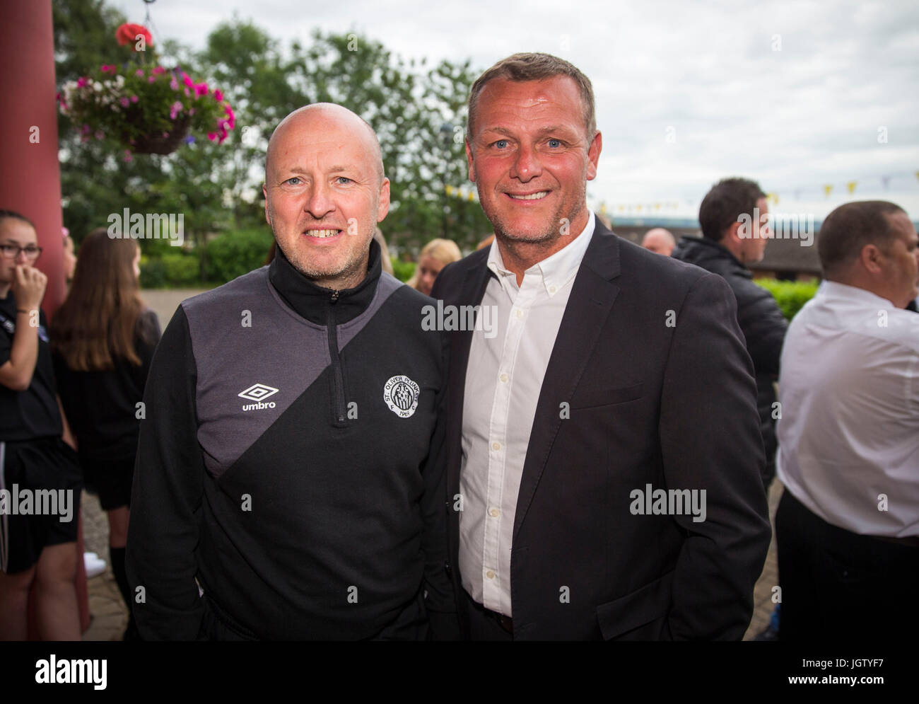 Il presidente di Sant'Oliviero Plunkett Football Club Martin McLaughlin (sinistra) con Jim Magilton, elite direttore delle prestazioni con la Irish Football Association, che frequentano la Messa inaugurale della ex Manchester United giocatore Philip Mulryne presso il St Oliver Plunkett chiesa nella parte occidentale di Belfast dopo la sua ordinazione. Foto Stock