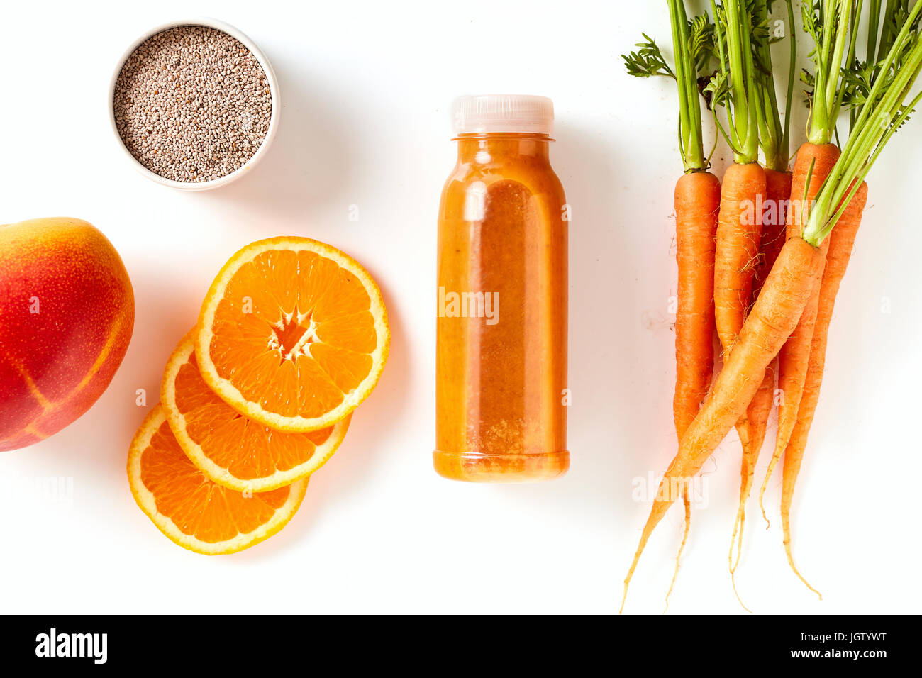 Carota sani, mango e orange smoothie con semi di chia per una colazione energizzante in una vista aerea della bevanda miscelata in una bottiglia con ing Foto Stock