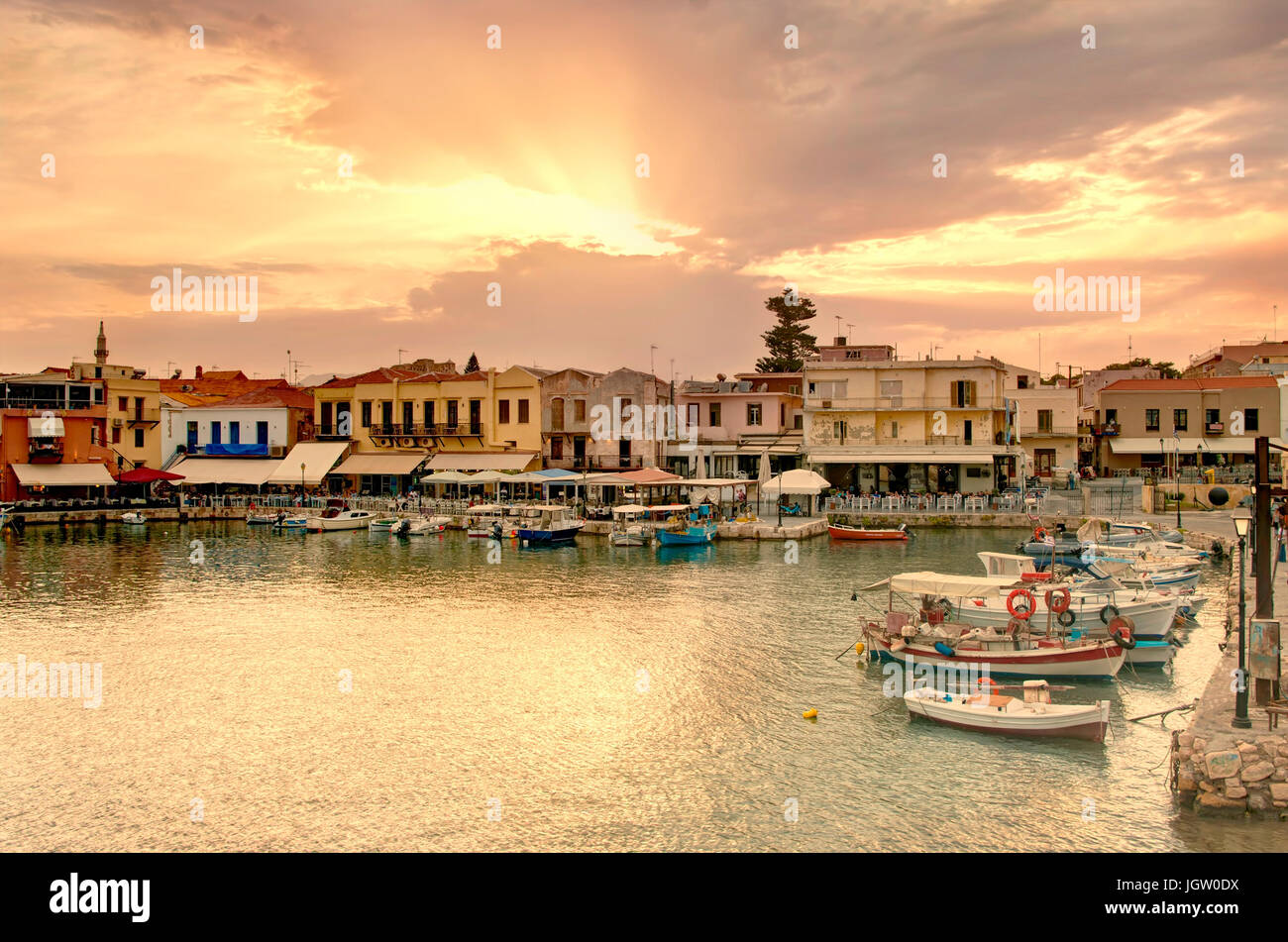 Rethymno porto vecchio con bar e ristoranti illuminata con luce calda del sole, Creta, Grecia Foto Stock