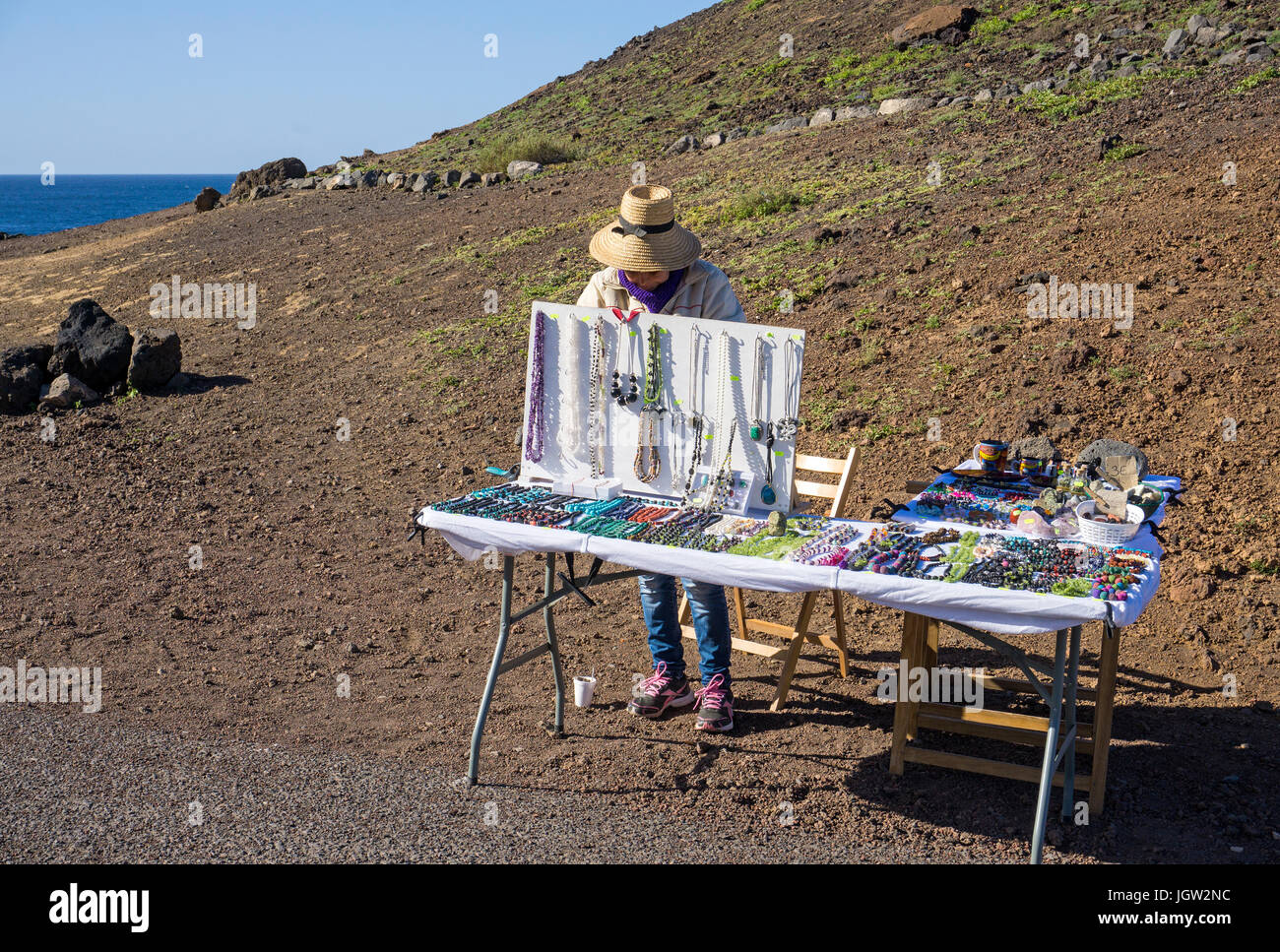 Donna locale vende gingillo alla spiaggia di lava, El Golfo, Lanzarote, Isole canarie, Spagna, Europa Foto Stock