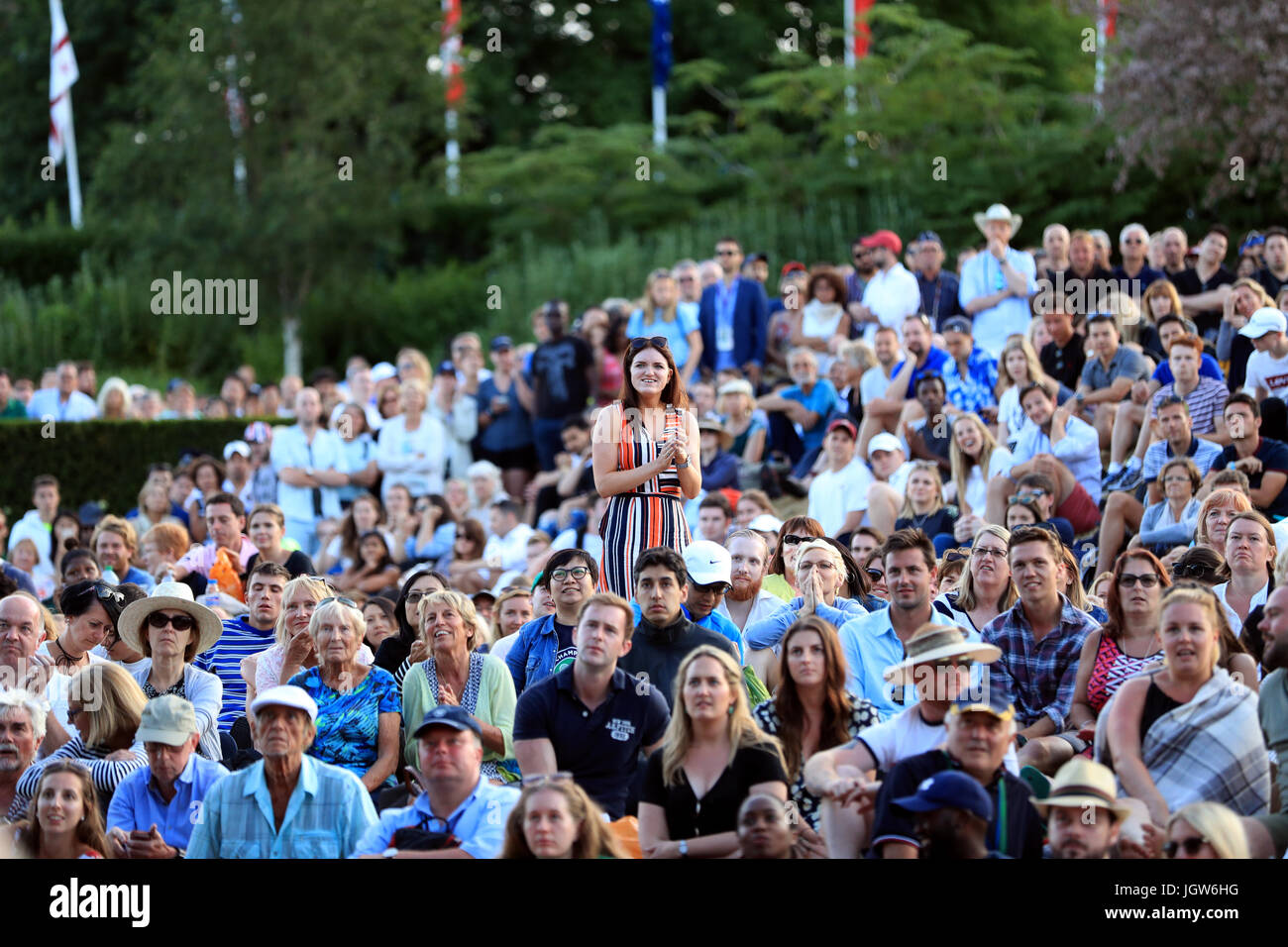 Gli spettatori di Murray Mound assistono alla partita di Rafael Nadal e Gilles Muller sul grande schermo il giorno sette dei campionati di Wimbledon all'All England Lawn Tennis and Croquet Club, Wimbledon. Foto Stock