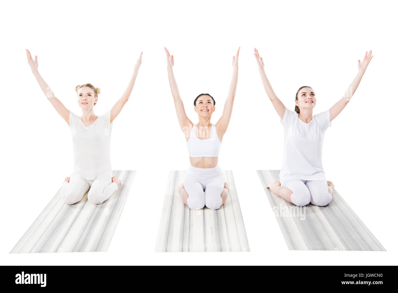 Il gruppo di allegro le donne a praticare yoga su Materassini da yoga isolato su bianco Foto Stock