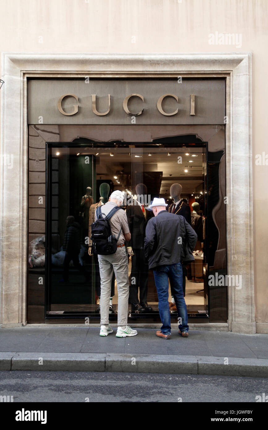 Pedoni guardare la finestra negozio di Gucci brand fashion store a Roma Italia Foto Stock