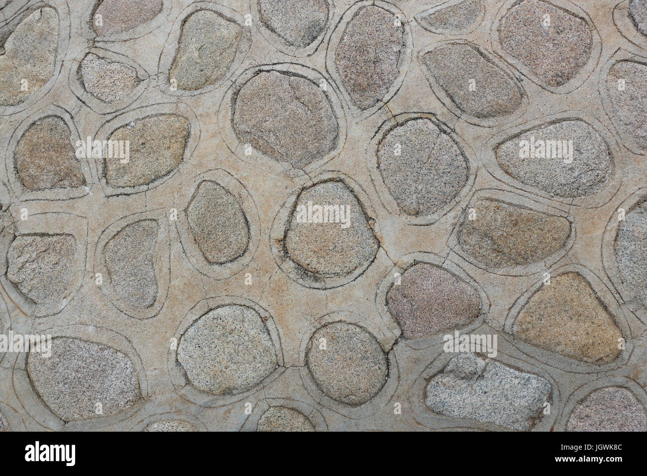 Primo piano di un marciapiede o patio costruito da rocce di affondamento in cemento, e incidendo un pattern intorno a ogni roccia; buona sfondo o carta da parati. Foto Stock