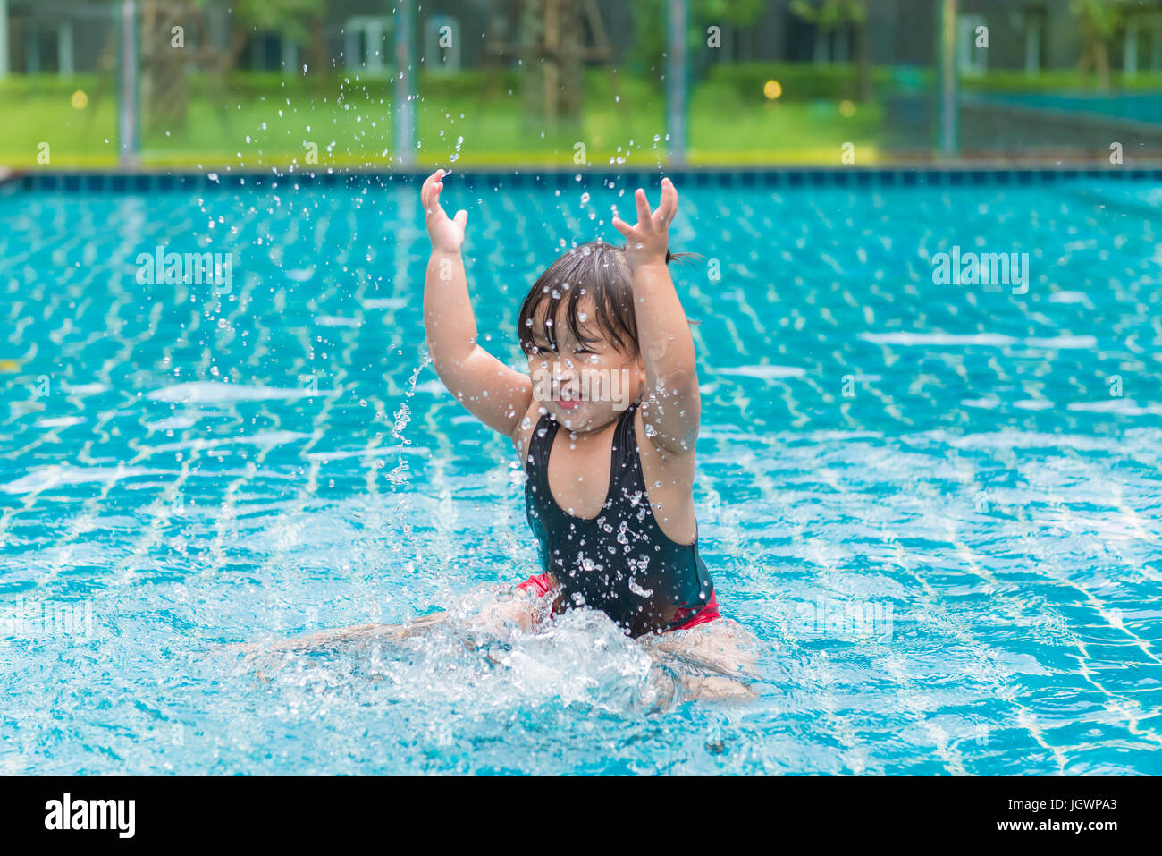 Ragazza carina o piccolo bambino a giocare in piscina felicemente. Foto Stock