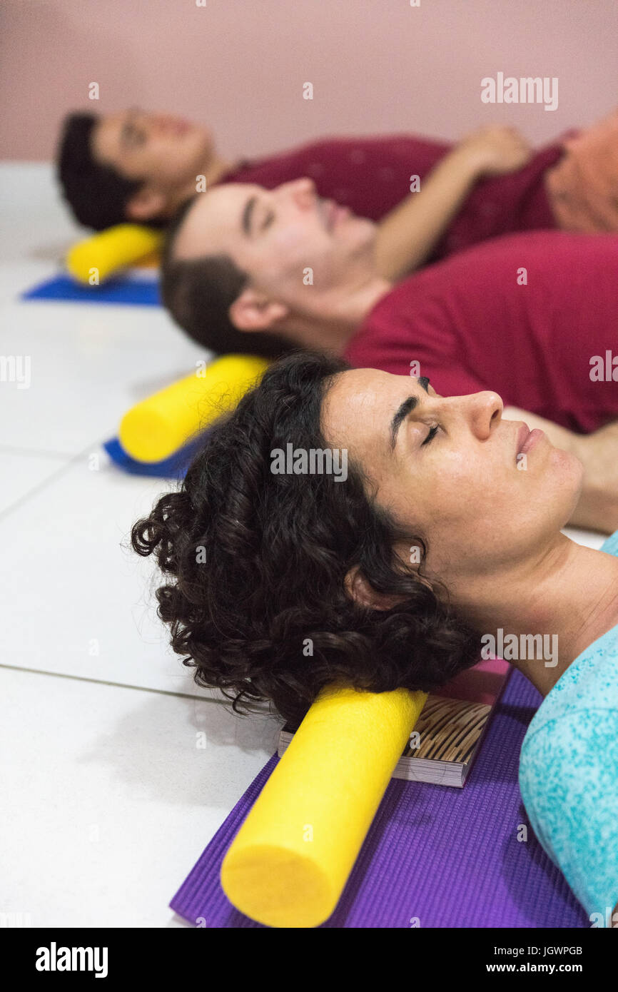 Persone a yoga classe appoggiato la testa sul blocco Foto Stock