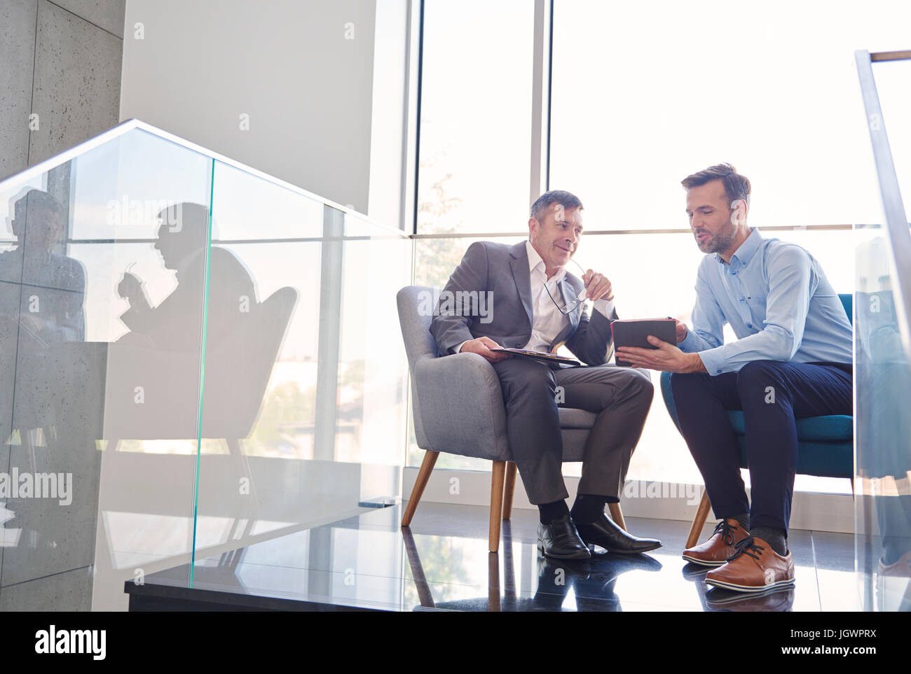 Gli uomini d' affari con tavoletta digitale in riunione Foto Stock
