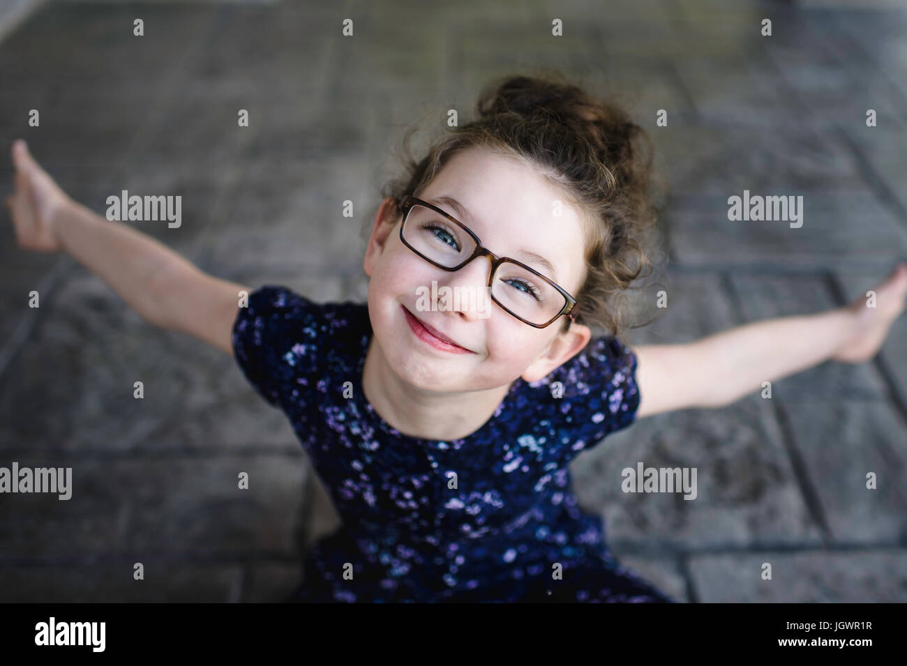 Ritratto di una ragazza che indossa occhiali cercando fino alla fotocamera Foto Stock