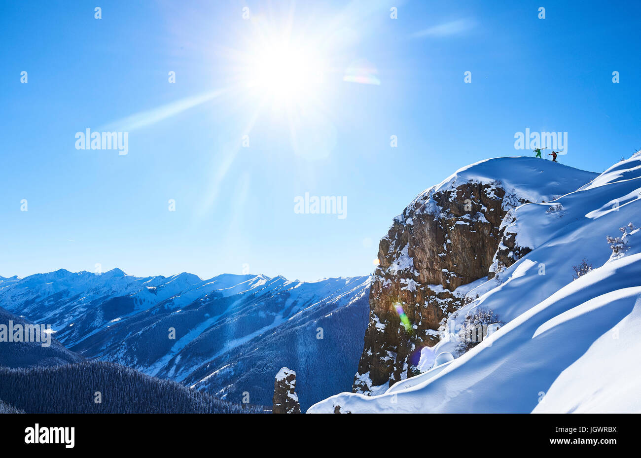 Vista in lontananza due sciatori maschio trascinarsi faticosamente fino coperta di neve ridge, Aspen, Colorado, STATI UNITI D'AMERICA Foto Stock