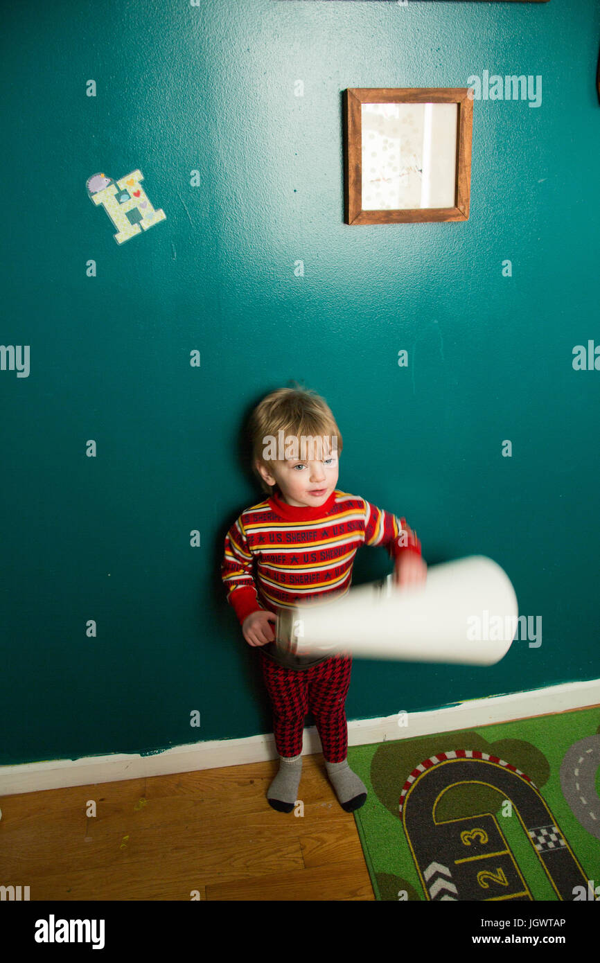 Carino toddler maschio carta di rotolamento in sala giochi Foto Stock