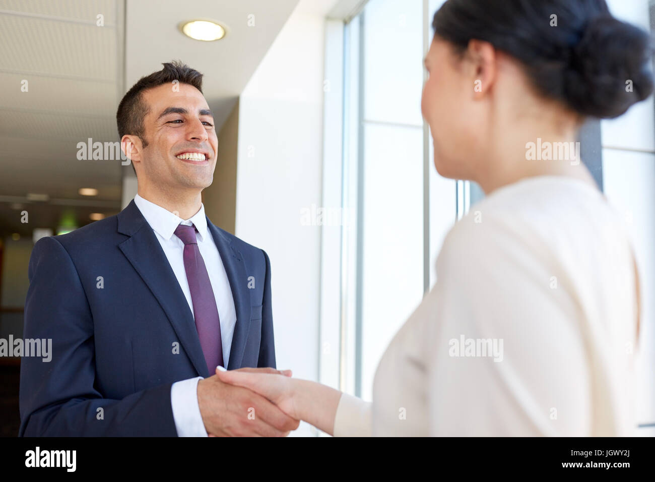 Sorridente la gente di affari si stringono la mano in ufficio Foto Stock