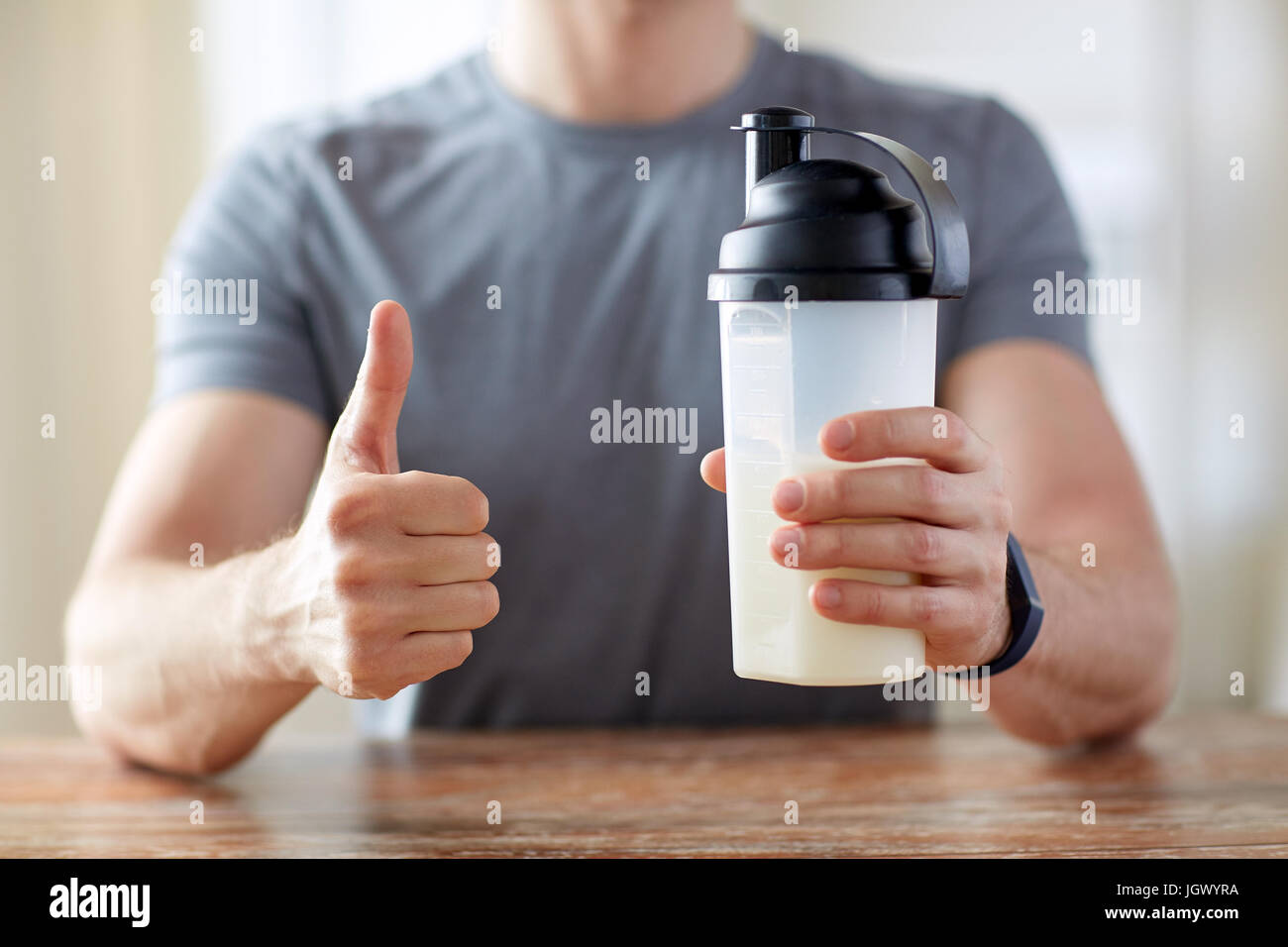 Uomo con cibo di proteina che mostra pollice in alto Foto Stock