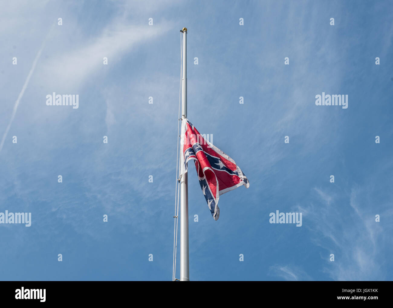 Columbia nella Carolina del Sud - Luglio, 10, 2017:un confederato bandiera si fa strada fino a bandiera portatile pole durante la bandiera Confederate sollevamento evento organizzato dalla Carolina del Sud partito secessionista in segno di protesta dei due anni di anniversario della battaglia Confederati Bandiera della rimozione dal South Carolina State House motivi nel 2015. Credito: schiacciare il lettore Rush/Alamy Live News Foto Stock