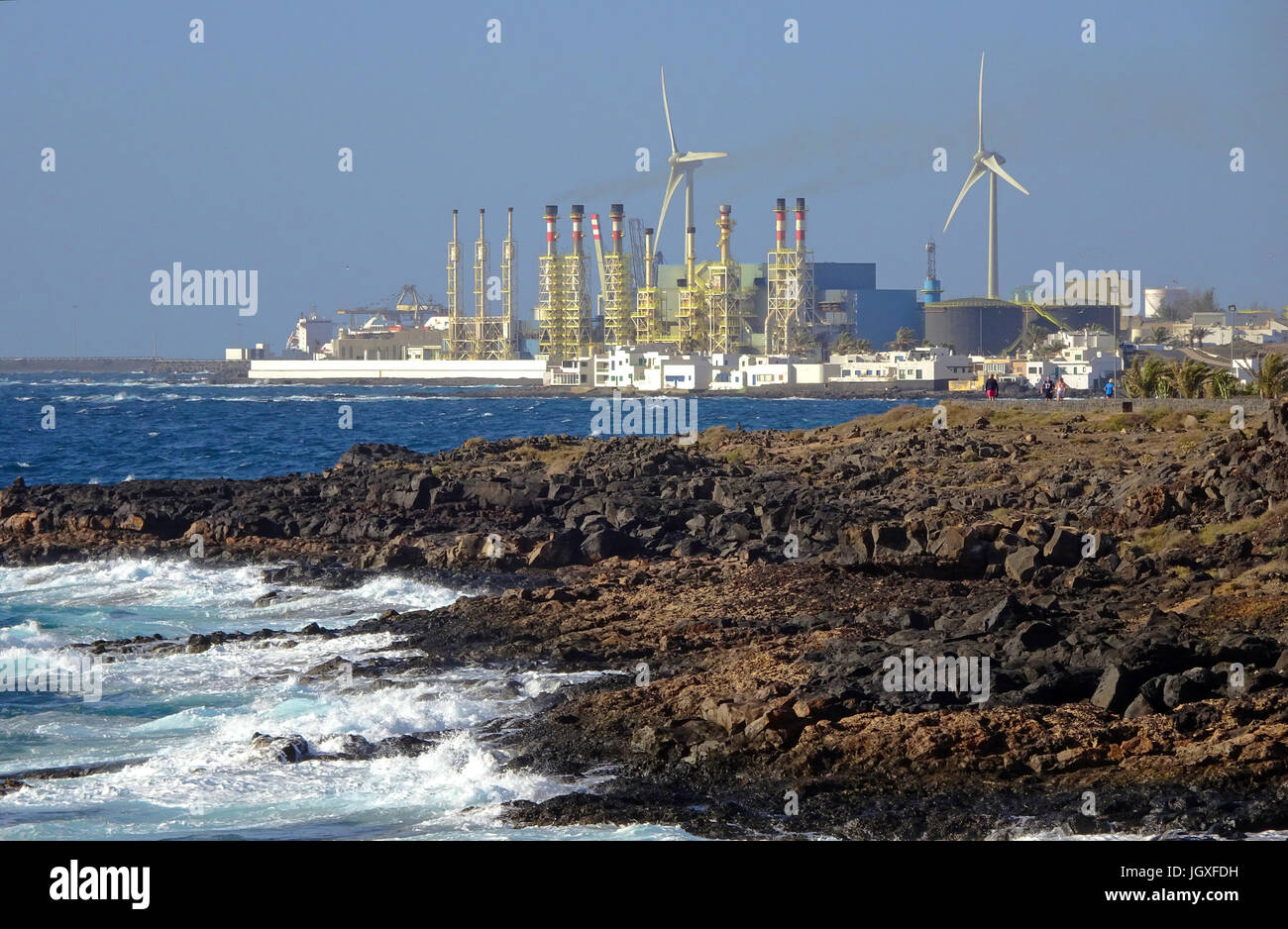 Felsige kueste bei costa teguise, blick auf die meerwasser-entsalzungsanlage von arrecife, Lanzarote, kanarische isole, europa | dispositivo di dissalazione Foto Stock