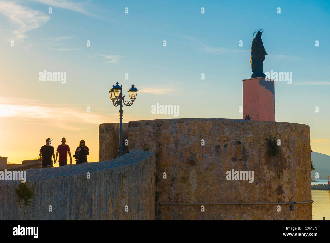 Alghero Sardegna lungomare con vista del muro fortificato e la statua del Cristo sulla Torre San Elmo lungo il lungomare di Alghero, Sardegna, Italia. Foto Stock