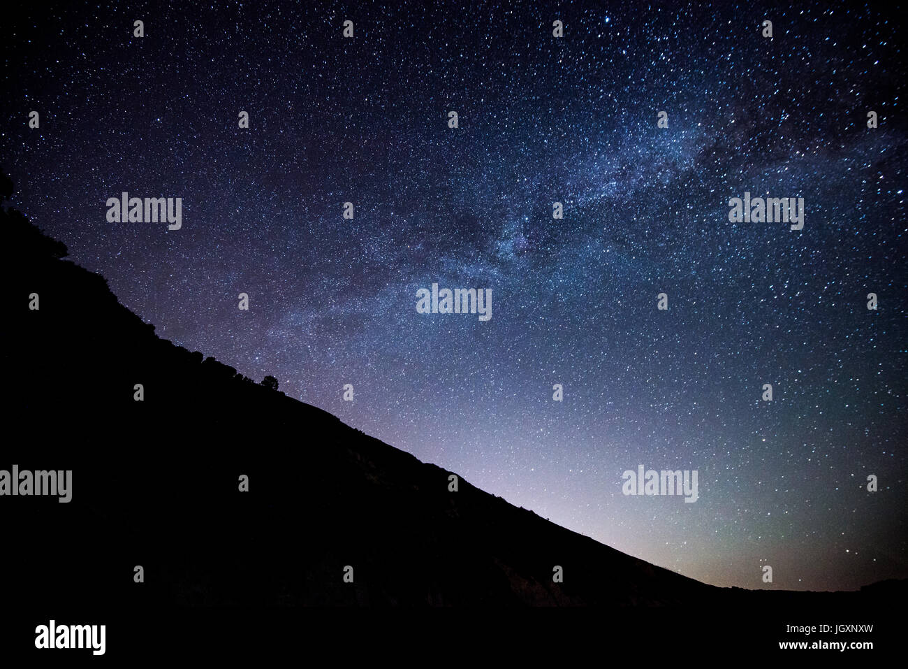 Chiari cieli sopra di Lulworth Cove rivelano la Via Lattea e milioni di stelle, Dorset, England, Regno Unito Foto Stock
