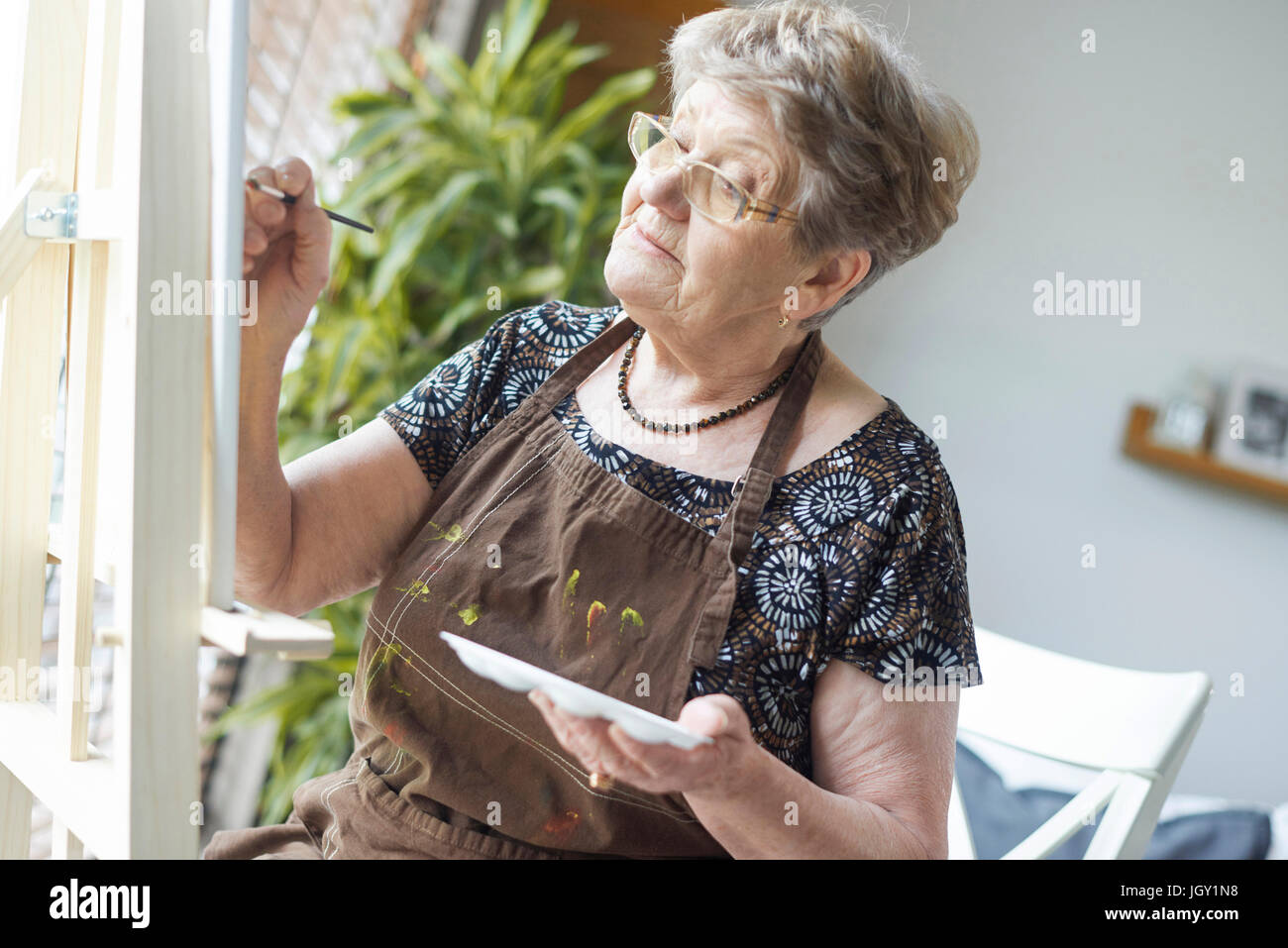 Senior donna adulta pittura su cavalletto Foto Stock