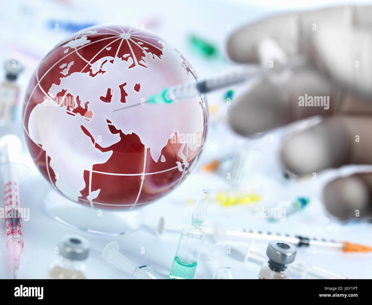 Medico iniettando il globo con vaccino per illustrare una cura per una pandemia globale Foto Stock