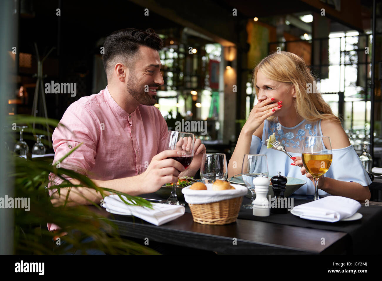 Giovane donna con il mio ragazzo a ridere al ristorante tabella Foto Stock