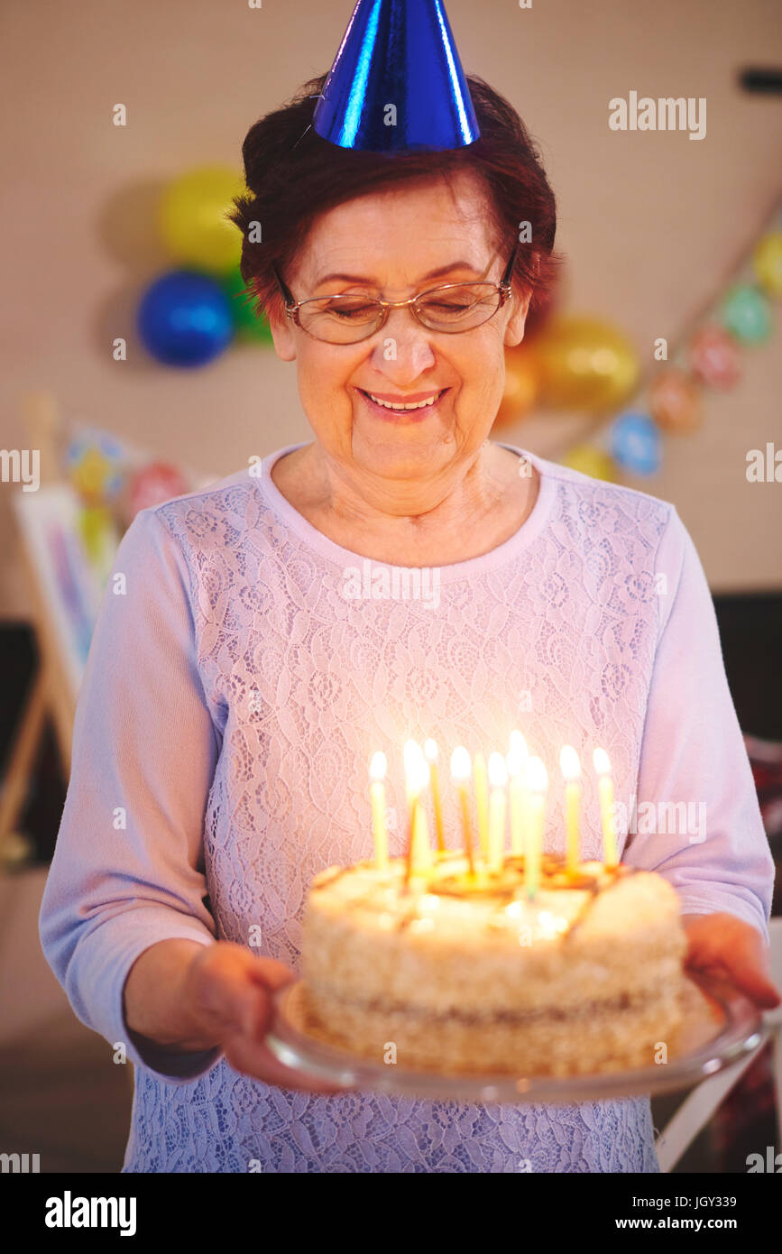 Senior donna con la torta di compleanno a parte Foto Stock