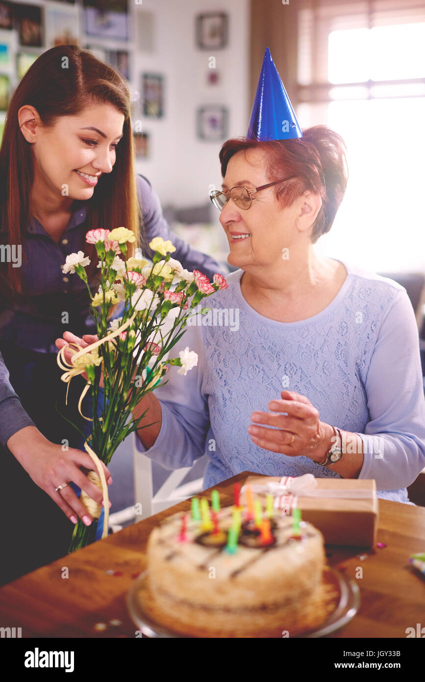 Figlia di dare madre fiori nella festa di compleanno Foto Stock