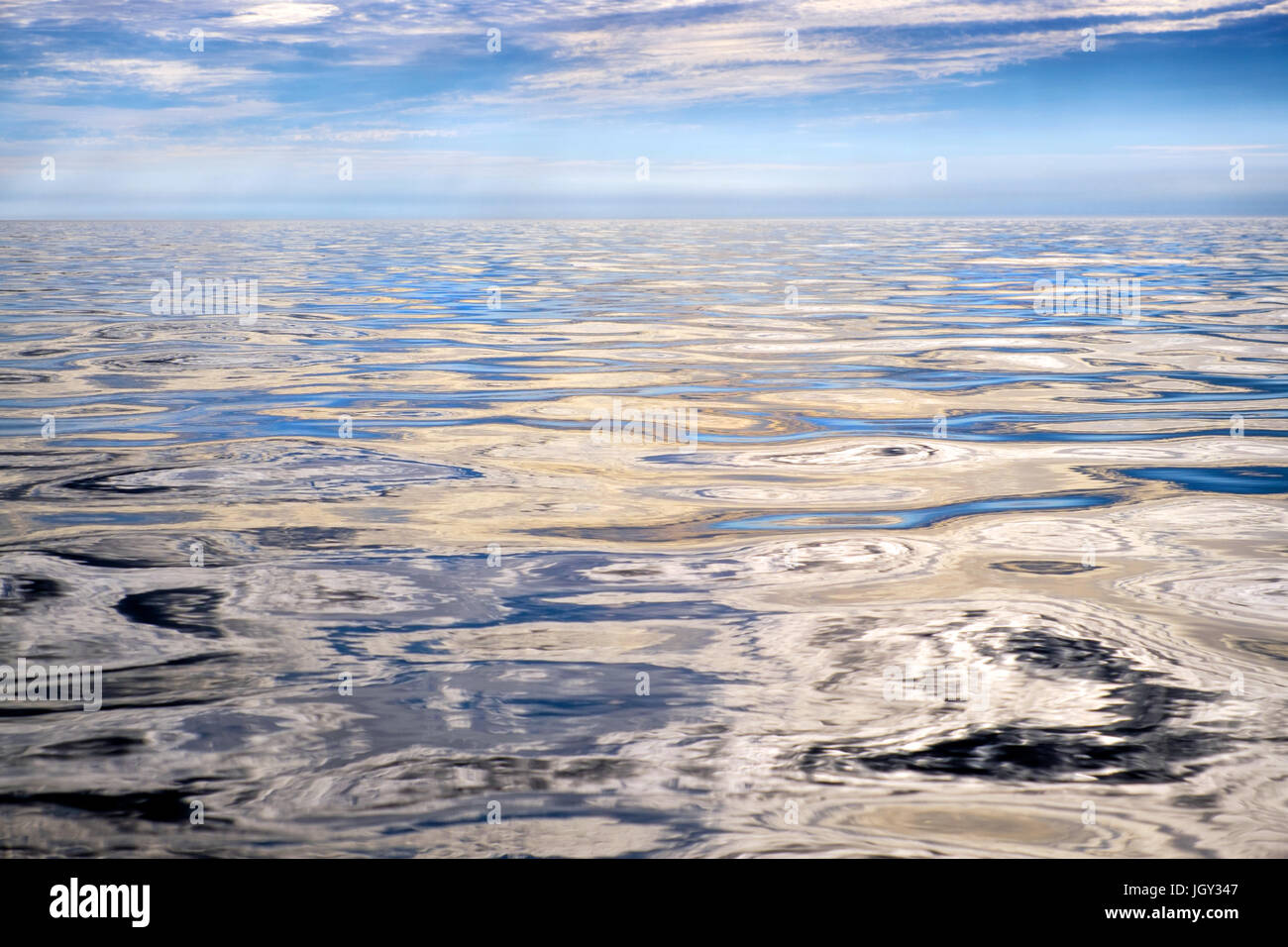Un liscio, lucido, vuoto mare di Anglesey, Galles, Regno Unito Foto Stock