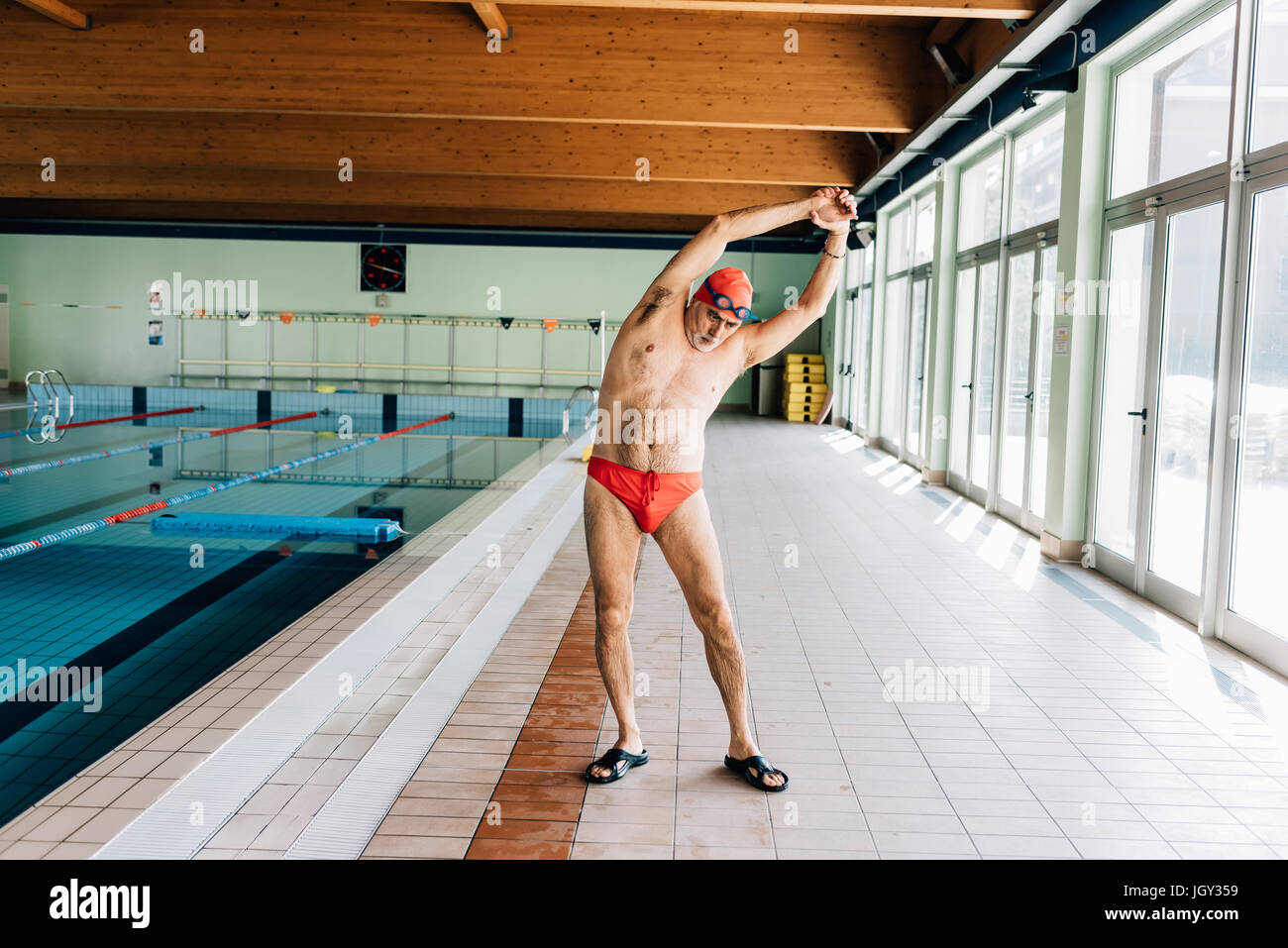 Senior uomo stretching da piscina Foto Stock