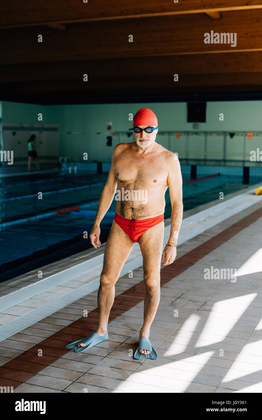 Senior man standing da piscina Foto Stock