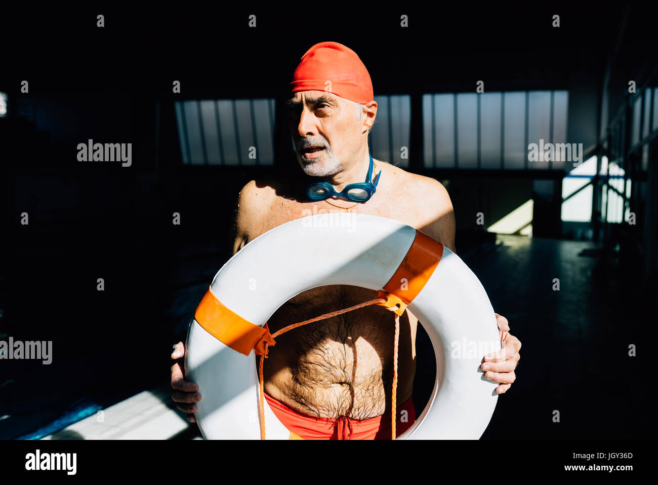 Senior uomo sul dazio bagnino holding galleggiante Foto Stock