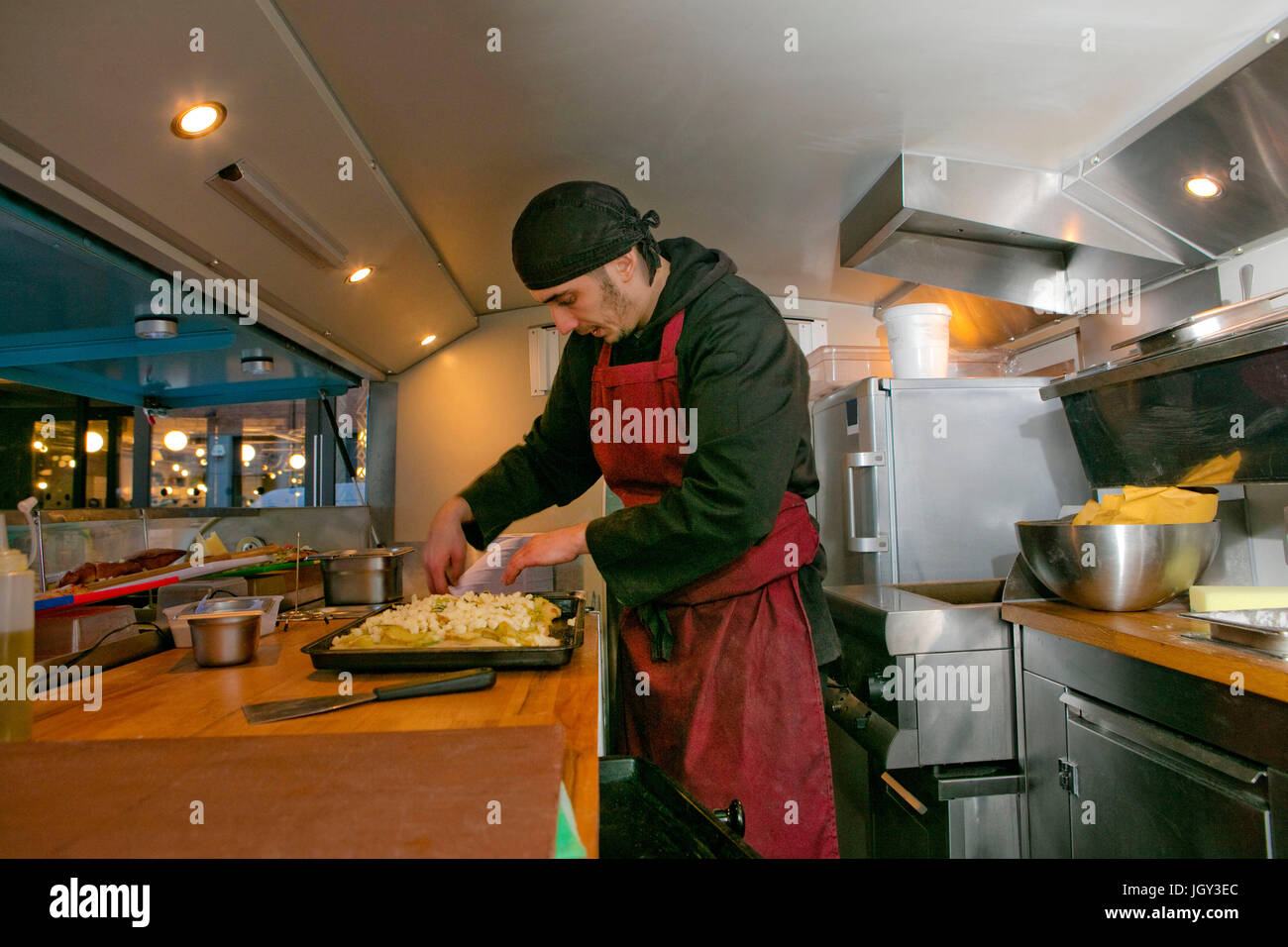 Lo chef prepara la pizza in stallo alimentare van di notte Foto Stock