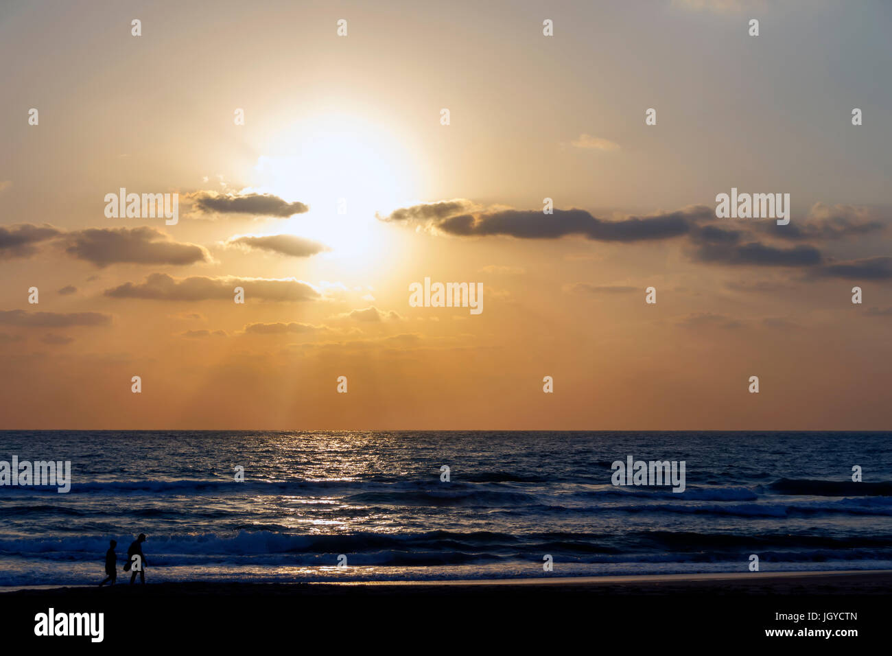 La gente contro lo sfondo del tramonto sul mare Foto Stock