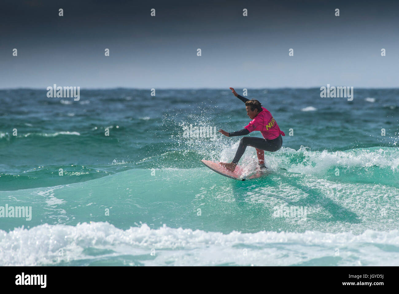 Navigare in UK. Un giovane maschio surfer competere nel Regno Unito scuole surf campionato.; Nerf scontro di Groms a Fistral in Newquay; Cornovaglia. Foto Stock