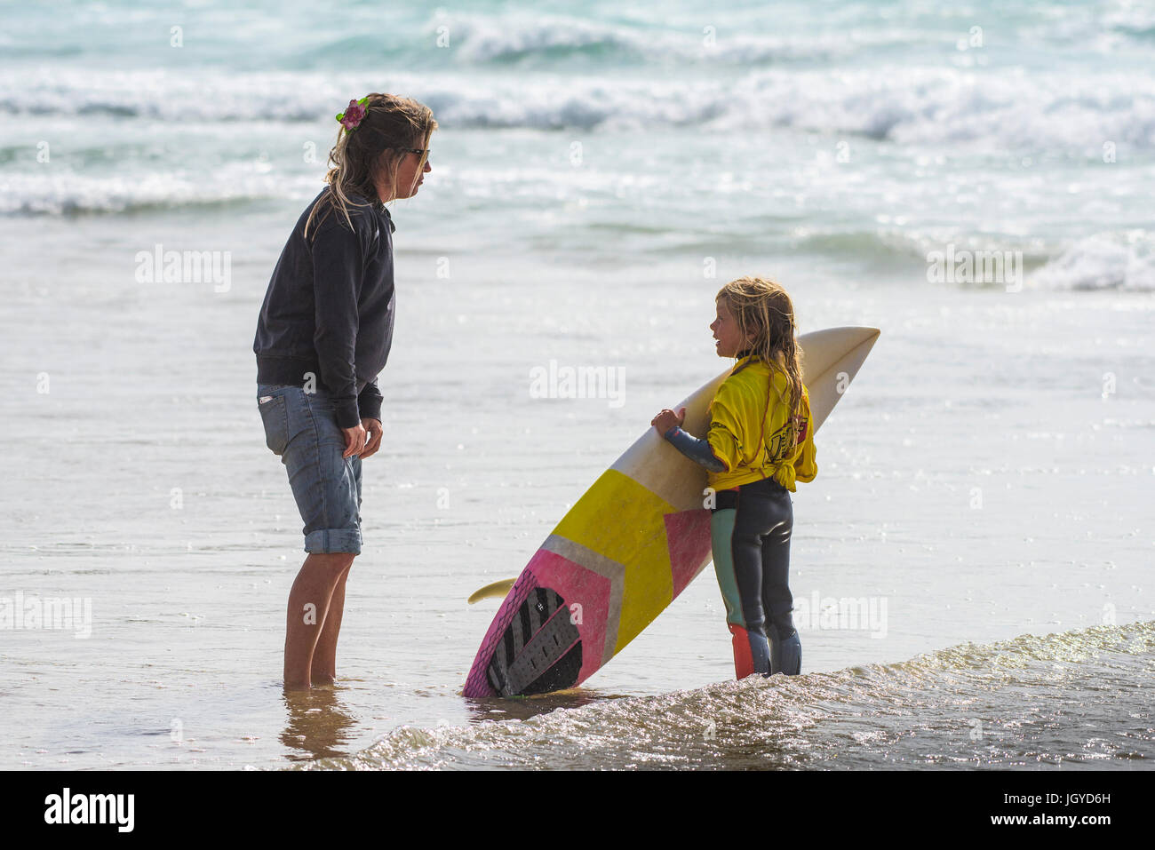 Navigare in UK. Un otto anni concorrente di surf a chiacchierare con la mamma prima di lei compete nel Regno Unito scuole surf campionato. Nerf scontro di Groms Foto Stock