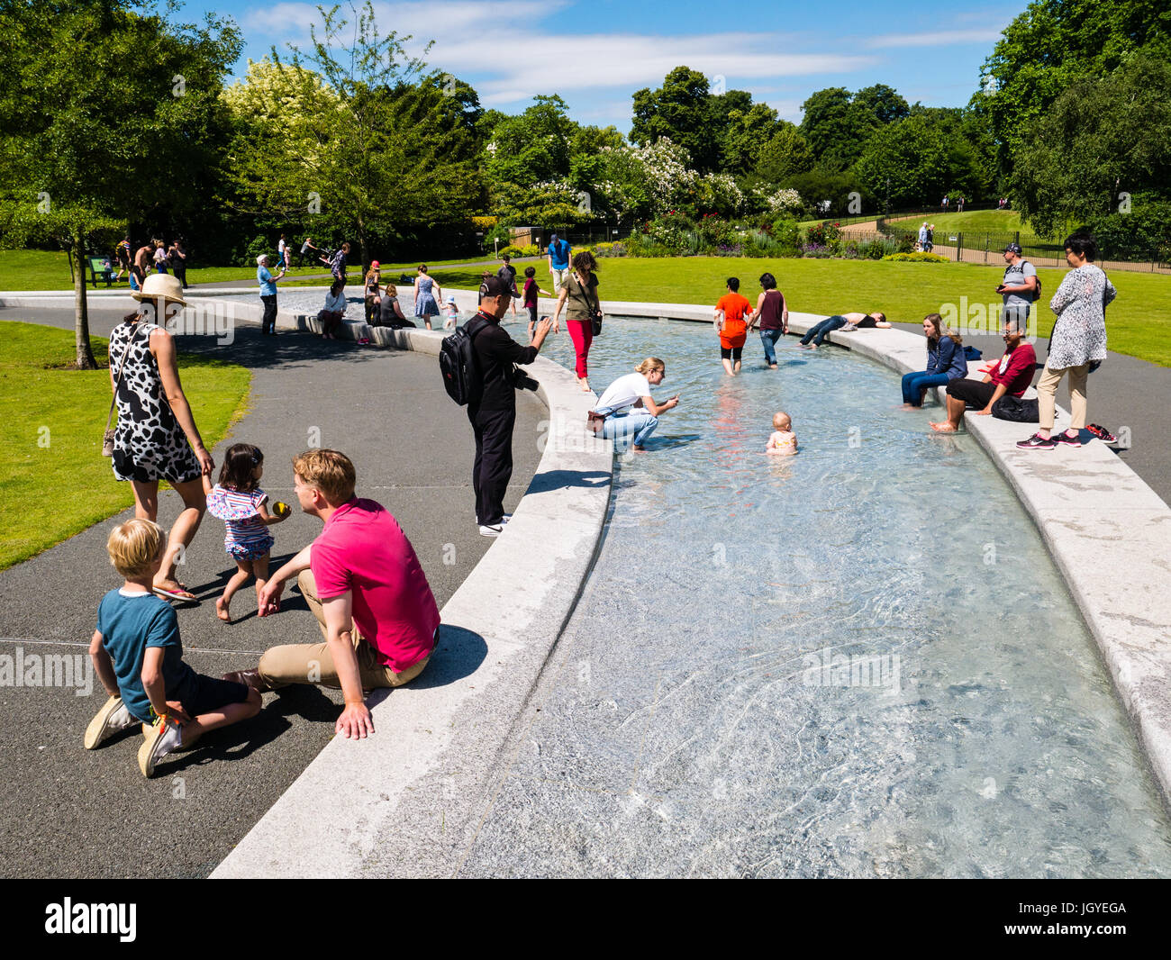 Per coloro che godono di sole, il Princess Diana Memorial Fountain, Hyde Park, Londra, Inghilterra, Regno Unito, GB. Foto Stock