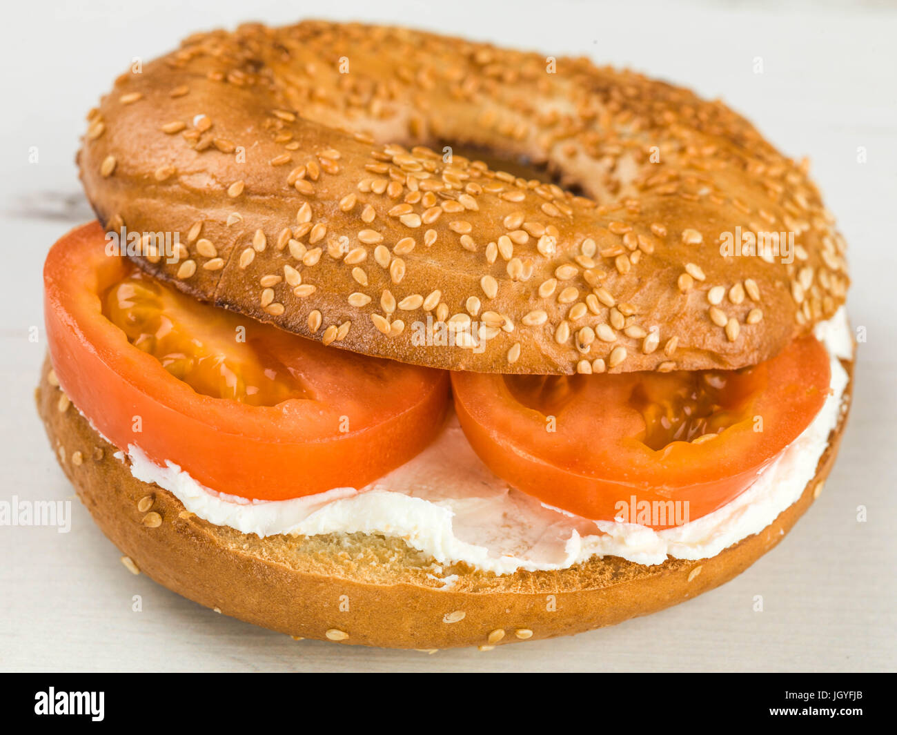 Pomodoro e formaggio semi di sesamo bagel contro uno sfondo bianco Foto Stock