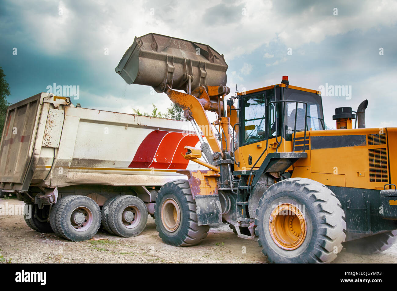 Carichi di escavatore ghiaia nel carrello Foto Stock