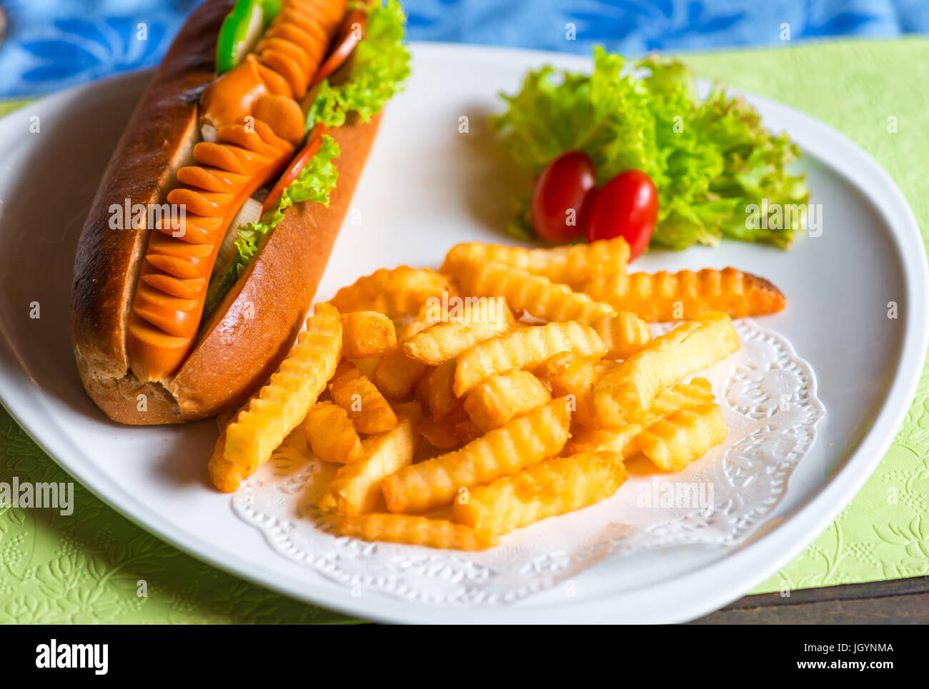 Fast food è ben servita su una piastra di hot dog e patate con verdure Foto Stock