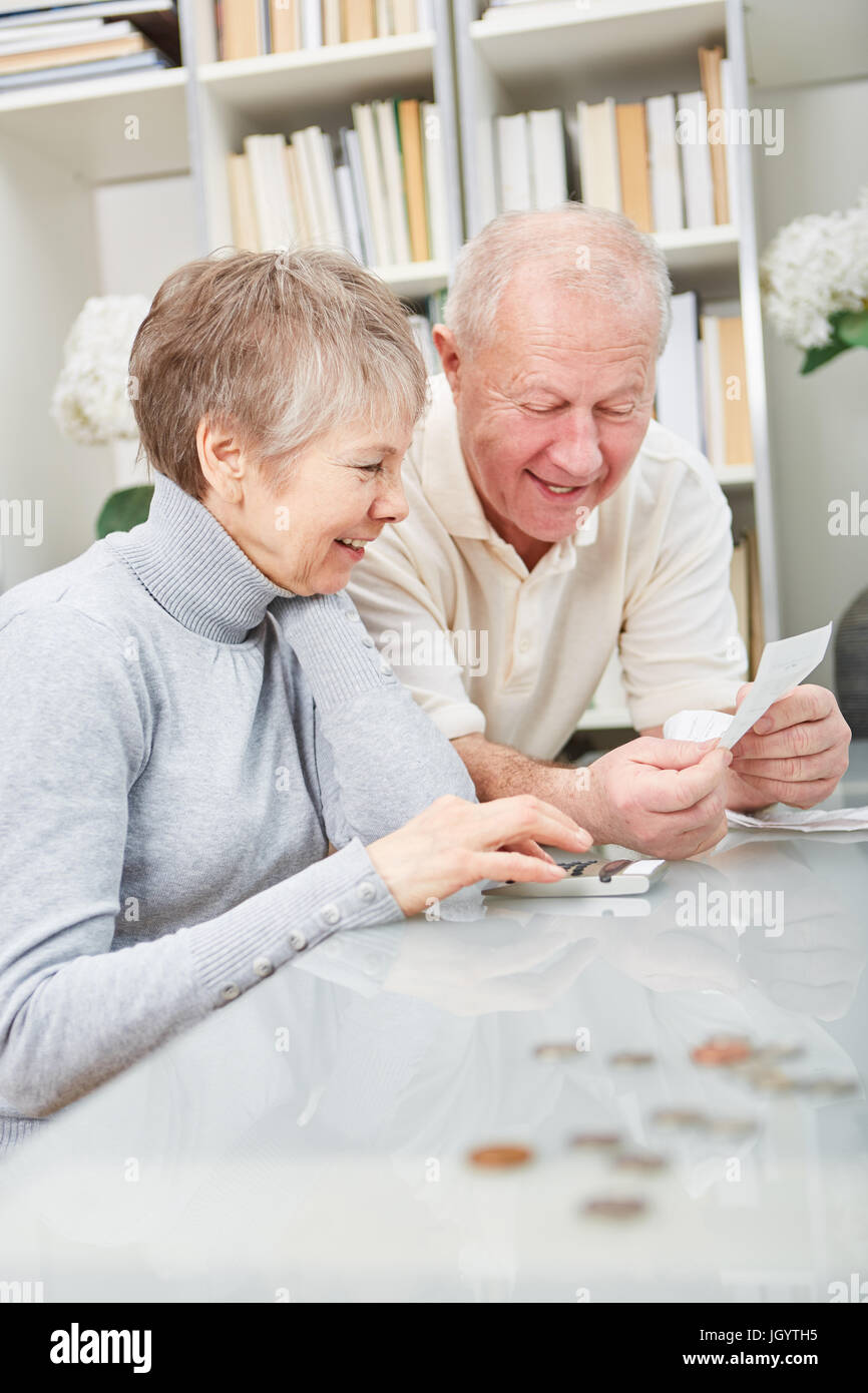 Senior pensioneers con calcolatrice facendo la contabilità finanziaria con gioia Foto Stock