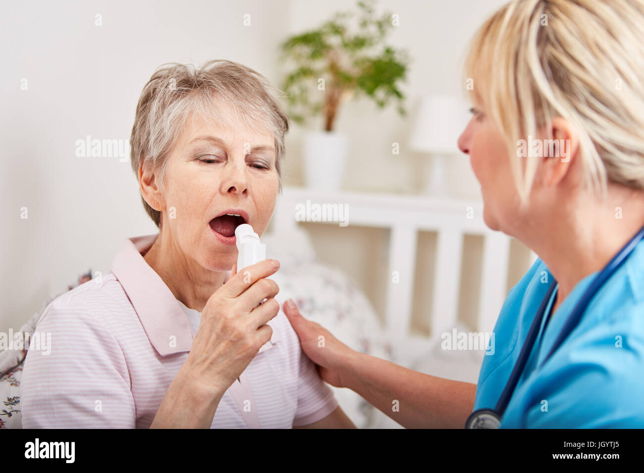Senior donna diventa primo aiuto da infermiera e usa inalatore Foto Stock