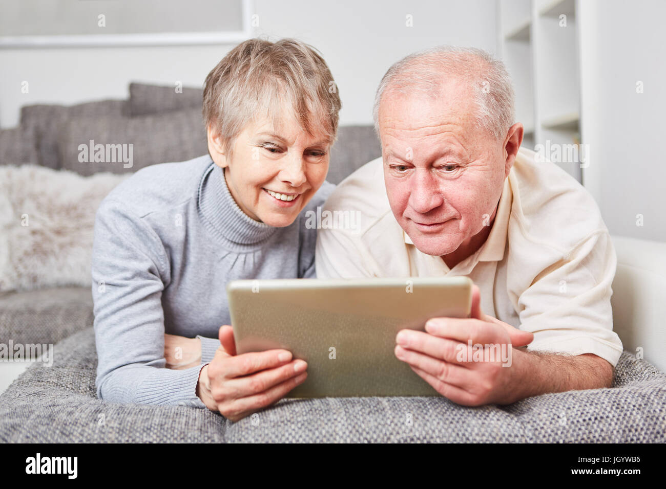 Coppia senior con computer tablet per navigare sul web con curiosità Foto Stock
